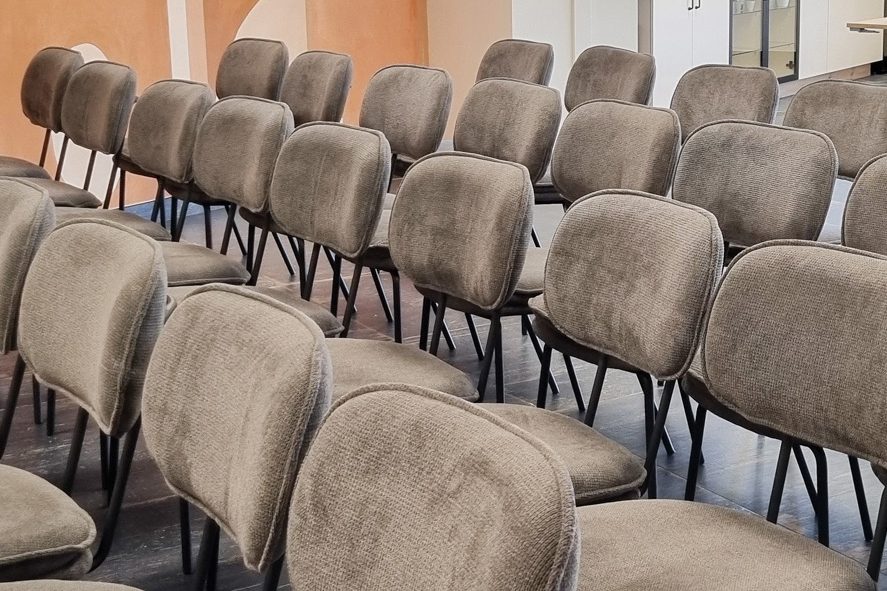 Rangées de chaises en velours gris installées en configuration conférence