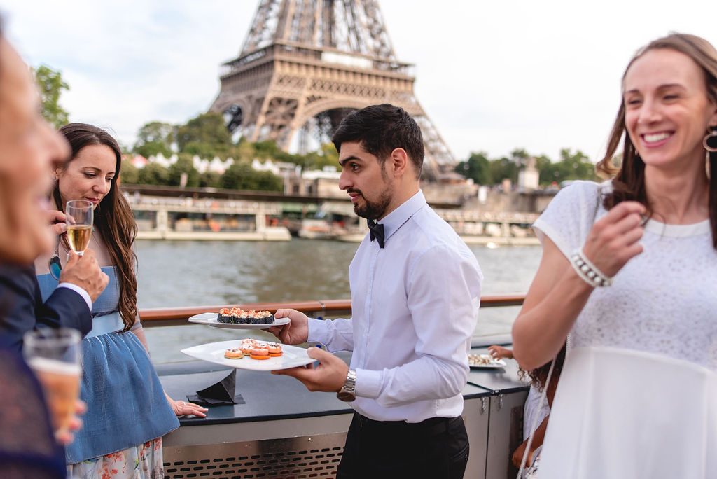 Invités servis en pièces cocktail sur le pont, la Tour Eiffel derrière eux