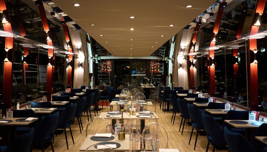 La salle du Théo dressée pour le dîner, lumières tamisées