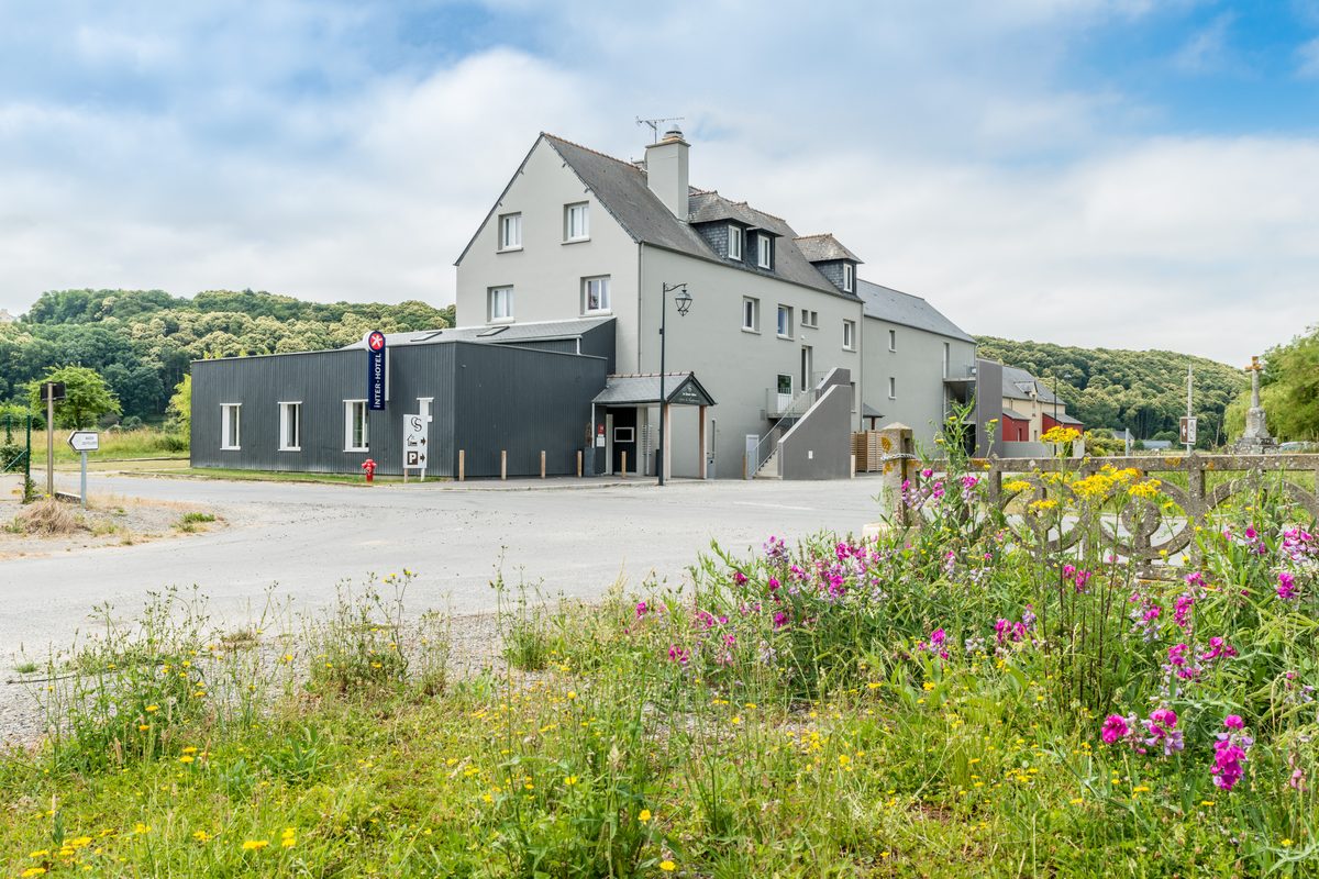 L'hôtel vu depuis la route, fleurs sauvages au premier plan