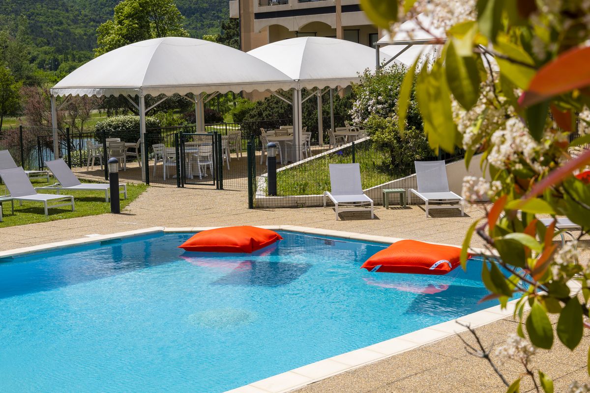 Piscine extérieure, transats et parasols blancs