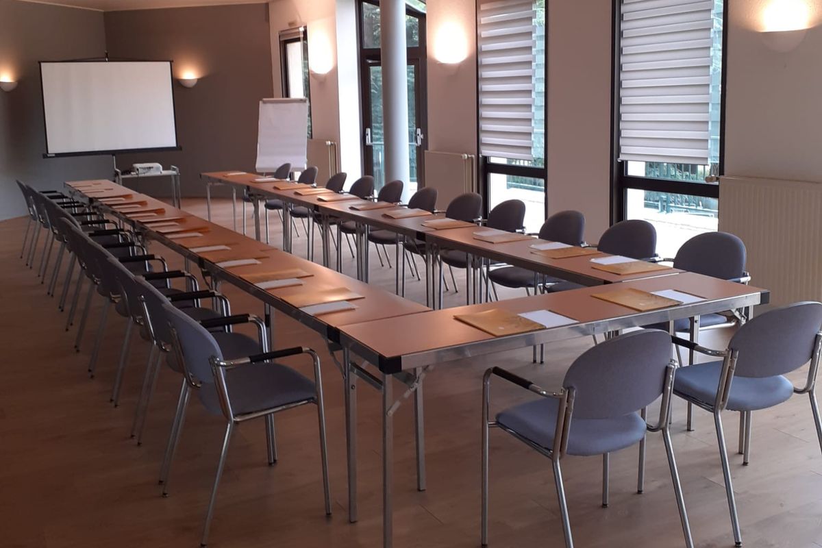 Salle de réunion aménagée en U, paperboard et écran de projection