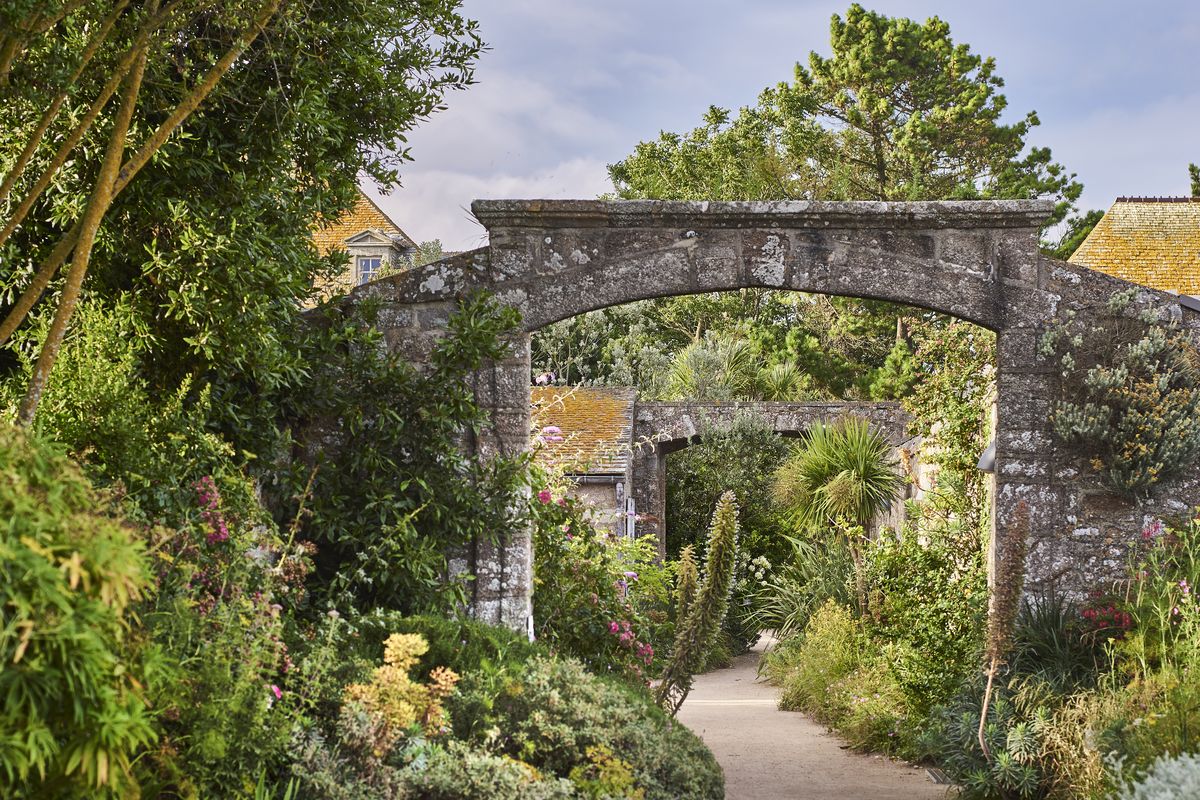 Arche de pierre ouvrant sur un jardin luxuriant