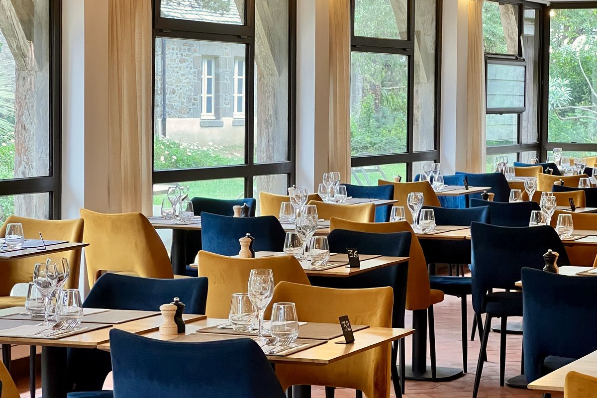 Salle du restaurant Le Carré, grandes baies vitrées et fauteuils colorés